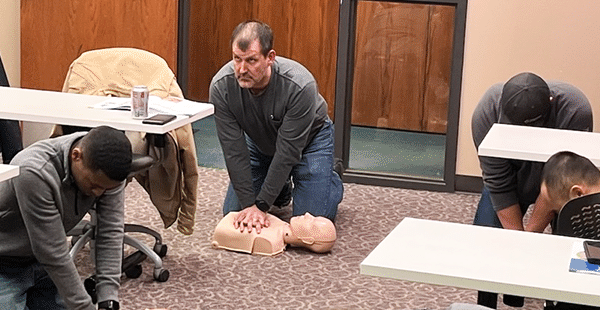 class practicing CPR on dummies